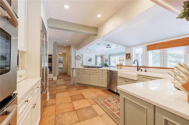 kitchen featuring sink, a wealth of natural light, stainless steel appliances, and kitchen peninsula