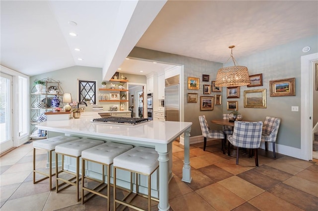 kitchen featuring lofted ceiling, a breakfast bar area, appliances with stainless steel finishes, kitchen peninsula, and pendant lighting