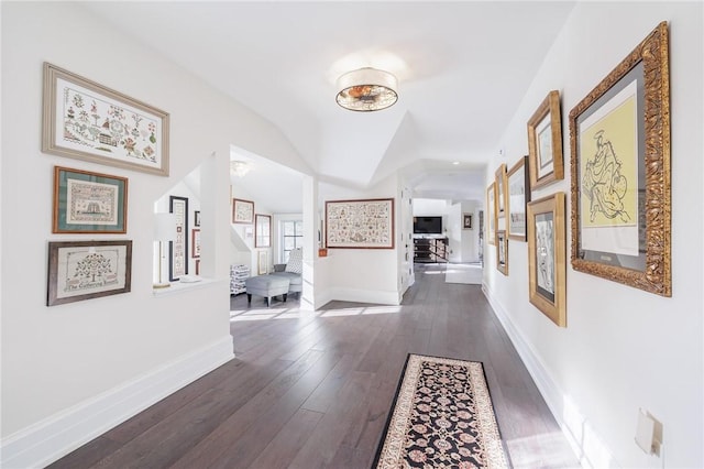 hall with vaulted ceiling and dark hardwood / wood-style floors