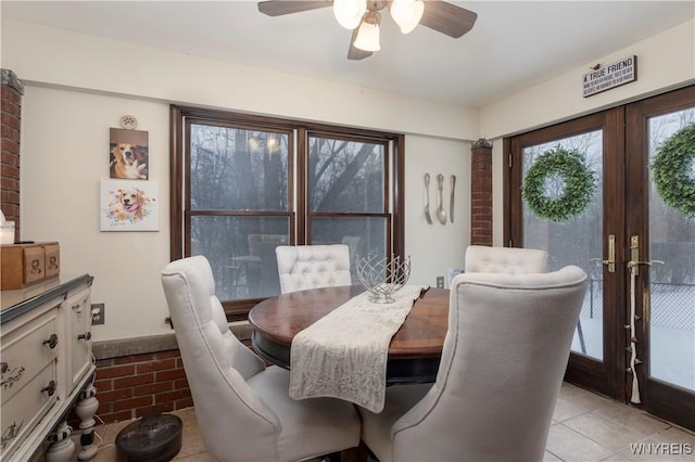 tiled dining room featuring ceiling fan and french doors