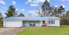 single story home featuring a garage and a front yard