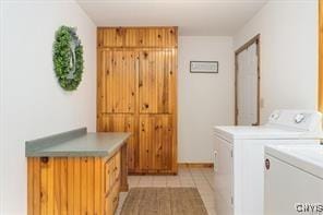 clothes washing area with cabinets, light tile patterned flooring, and separate washer and dryer