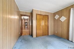 additional living space with light carpet and wood walls