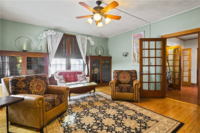 sitting room featuring french doors, ceiling fan, and wood-type flooring