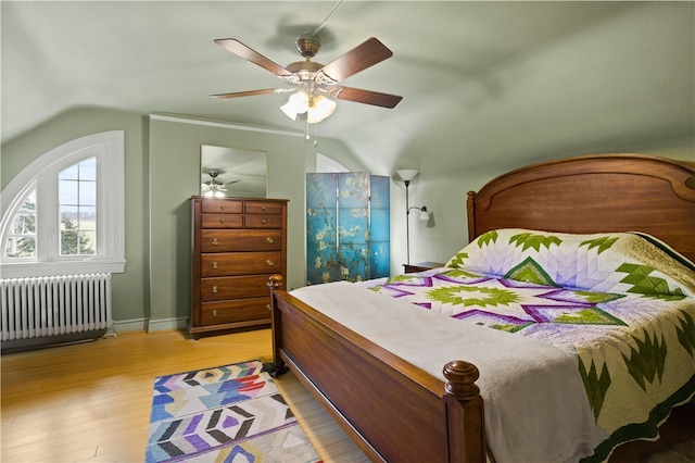 bedroom with ceiling fan, lofted ceiling, radiator, and light hardwood / wood-style floors