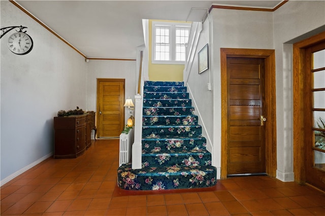 staircase featuring ornamental molding and tile patterned flooring