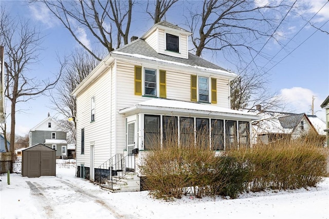 view of front facade featuring a sunroom and a shed