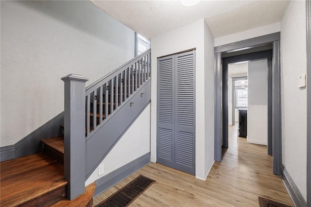 stairway featuring wood-type flooring and a textured ceiling