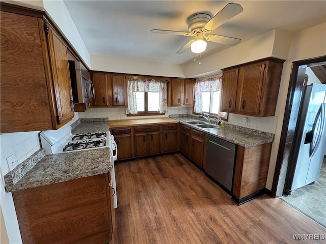 kitchen featuring sink, dark wood-type flooring, ceiling fan, appliances with stainless steel finishes, and tasteful backsplash