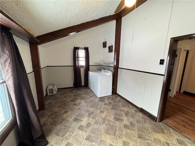 laundry room with washing machine and clothes dryer and a textured ceiling