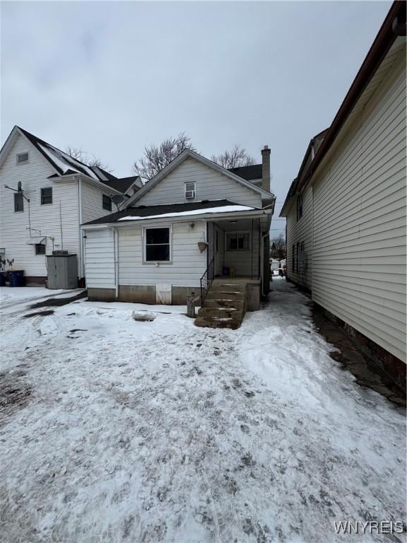 view of snow covered back of property