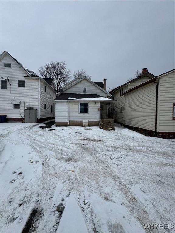 view of snow covered back of property