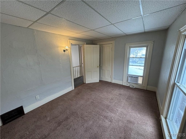 unfurnished room featuring carpet, a paneled ceiling, and cooling unit