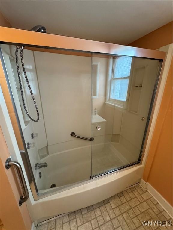 bathroom featuring shower / bath combination with glass door