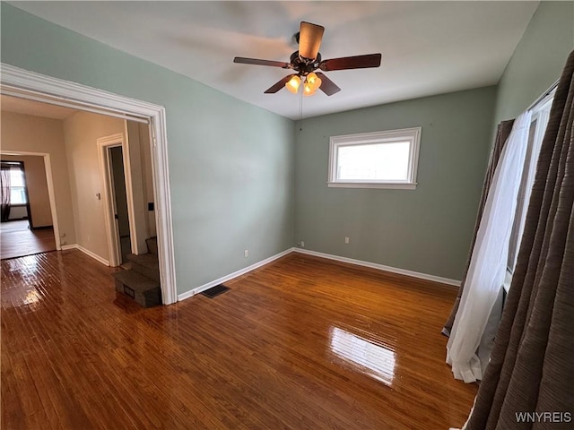 empty room featuring wood-type flooring, ceiling fan, and plenty of natural light