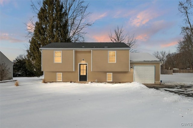 snow covered house with a garage