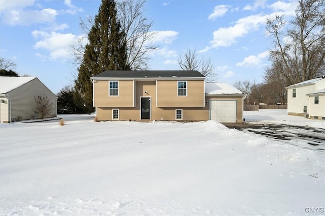 snow covered property featuring a garage