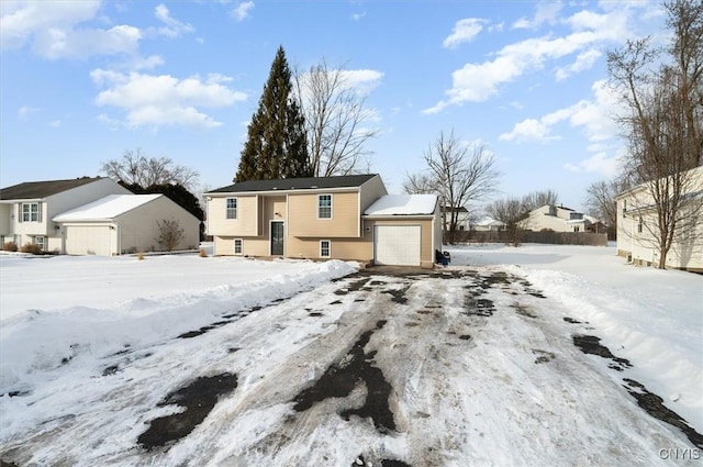 snow covered rear of property with a garage