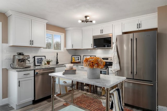 kitchen featuring white cabinetry, decorative backsplash, and stainless steel appliances