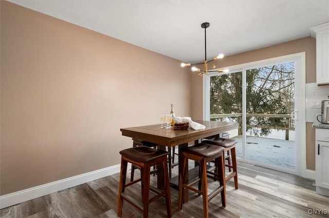 dining space featuring light hardwood / wood-style floors and a notable chandelier