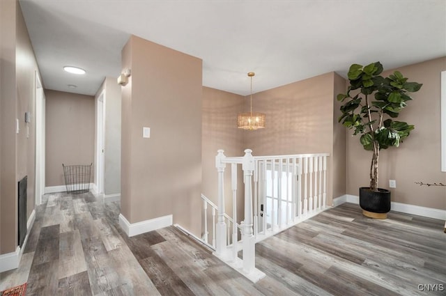 corridor featuring hardwood / wood-style flooring and a chandelier