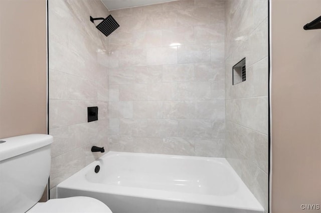 bathroom featuring tiled shower / bath combo and toilet