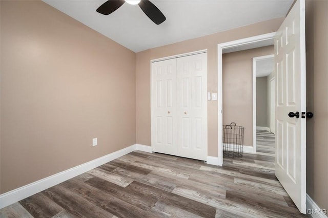 unfurnished bedroom with ceiling fan, hardwood / wood-style floors, and a closet