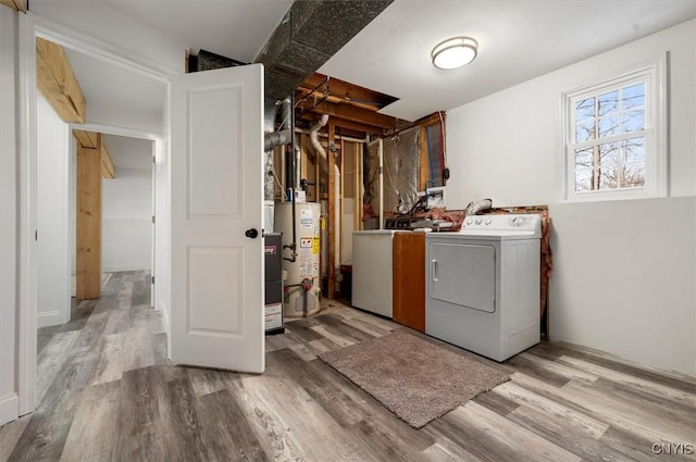 clothes washing area featuring gas water heater, independent washer and dryer, and light hardwood / wood-style flooring