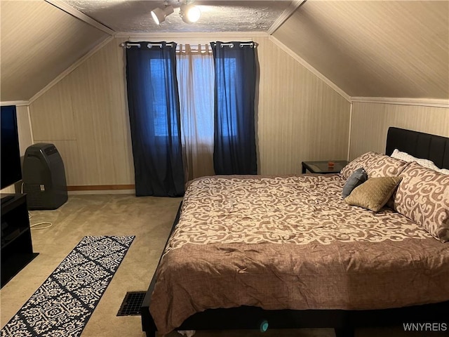 carpeted bedroom featuring vaulted ceiling and wooden walls