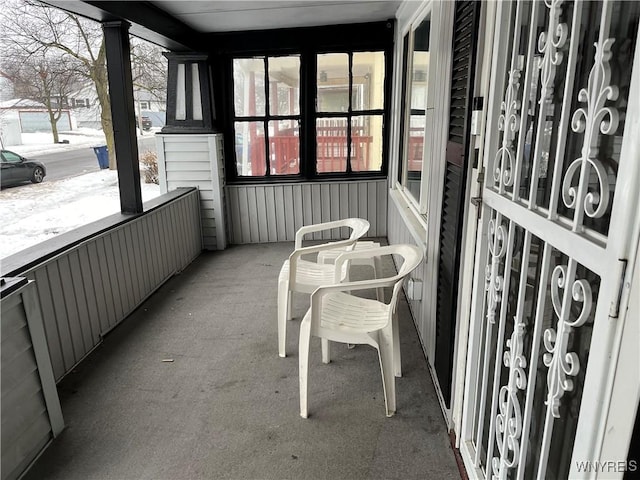 snow covered back of property with a porch