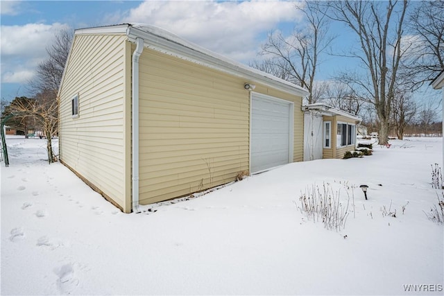 snow covered property with a garage