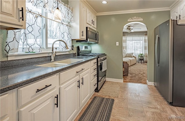 kitchen featuring sink, ceiling fan, appliances with stainless steel finishes, white cabinetry, and ornamental molding