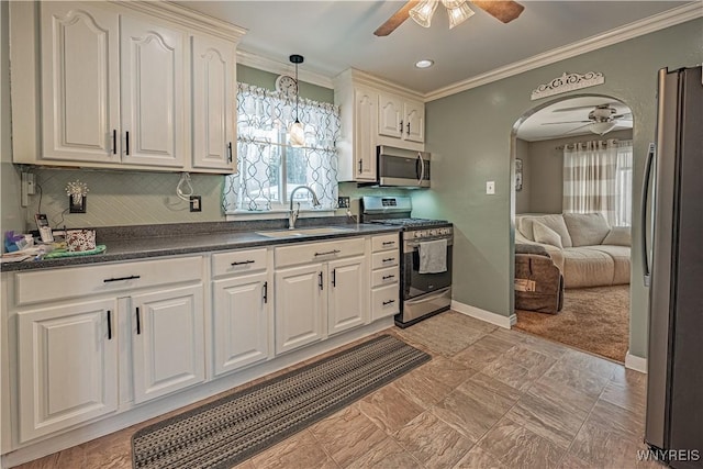 kitchen featuring sink, ceiling fan, appliances with stainless steel finishes, ornamental molding, and white cabinets