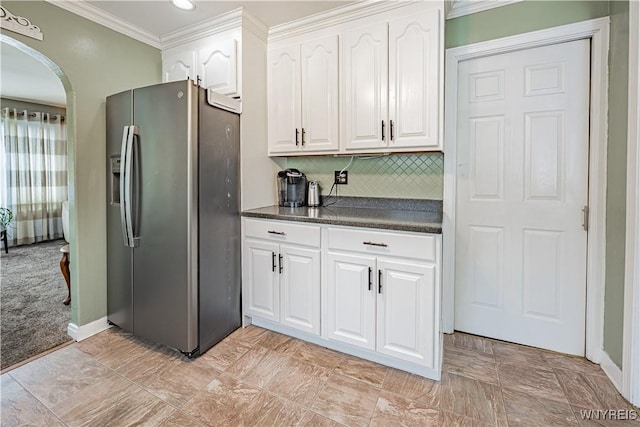 kitchen featuring stainless steel refrigerator with ice dispenser, backsplash, crown molding, and white cabinets