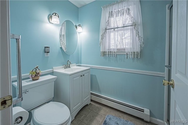 bathroom featuring vanity, a baseboard heating unit, and toilet