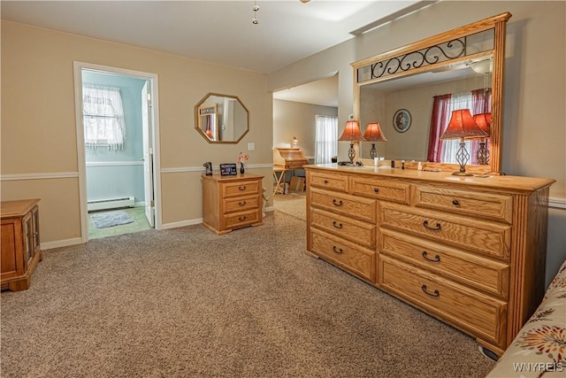 carpeted bedroom featuring a baseboard heating unit and ensuite bathroom