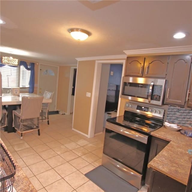 kitchen with crown molding, appliances with stainless steel finishes, light tile patterned flooring, and backsplash