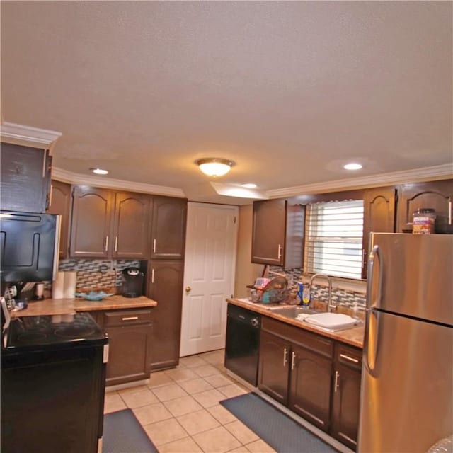 kitchen with light tile patterned flooring, sink, decorative backsplash, dark brown cabinetry, and black appliances