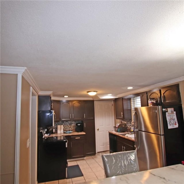 kitchen with stainless steel refrigerator, tasteful backsplash, light tile patterned floors, dark brown cabinets, and a textured ceiling