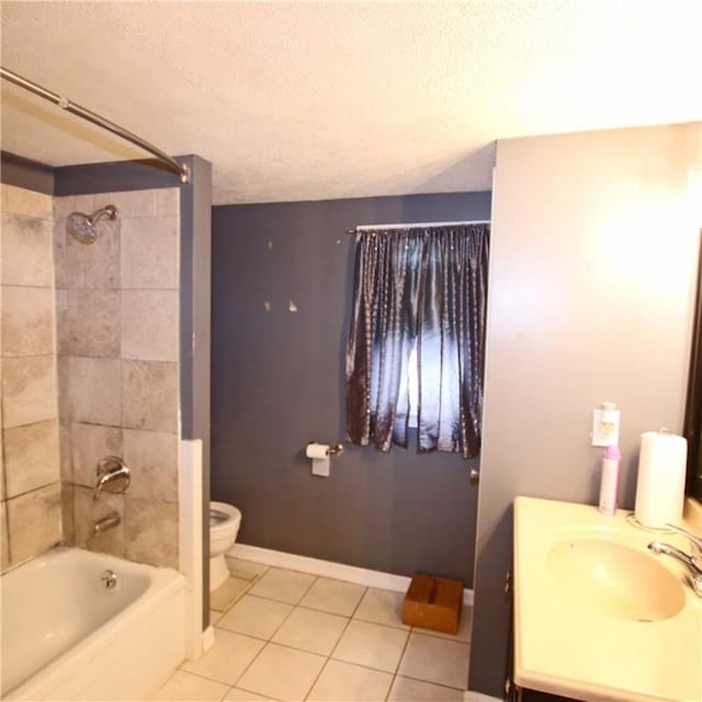 full bathroom with toilet, tiled shower / bath, a textured ceiling, vanity, and tile patterned flooring