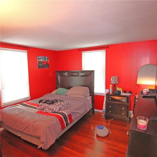 bedroom featuring multiple windows and dark hardwood / wood-style floors