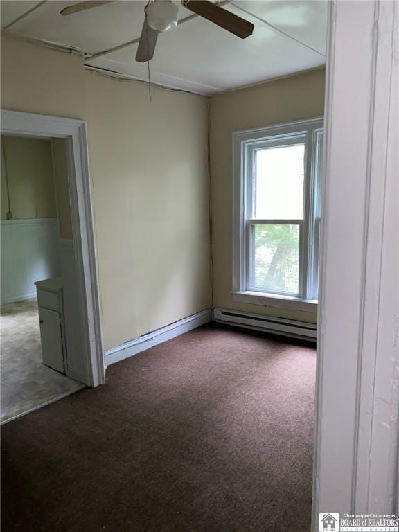 spare room with baseboard heating, ceiling fan, and carpet floors