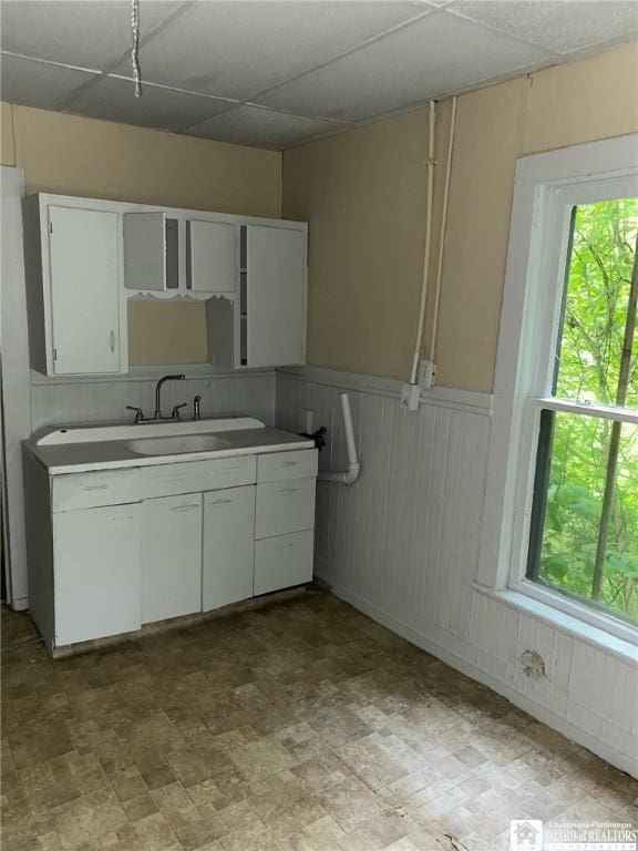 kitchen featuring sink, a paneled ceiling, and white cabinets