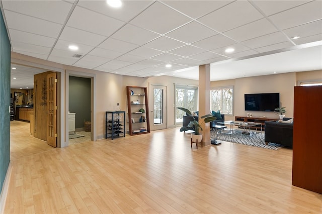 exercise area featuring a drop ceiling and light wood-type flooring