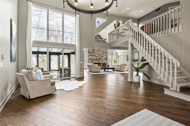 foyer featuring dark hardwood / wood-style flooring, a brick fireplace, and a healthy amount of sunlight