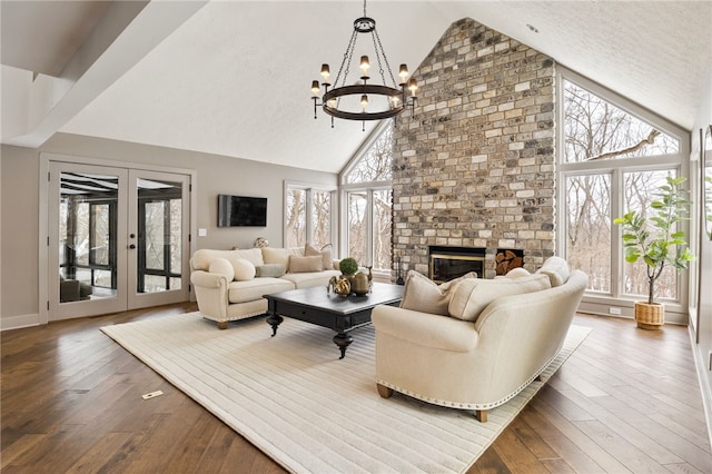 living room featuring a large fireplace, dark wood-type flooring, french doors, and plenty of natural light