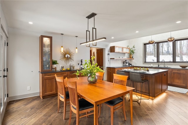 dining area featuring sink and dark wood-type flooring