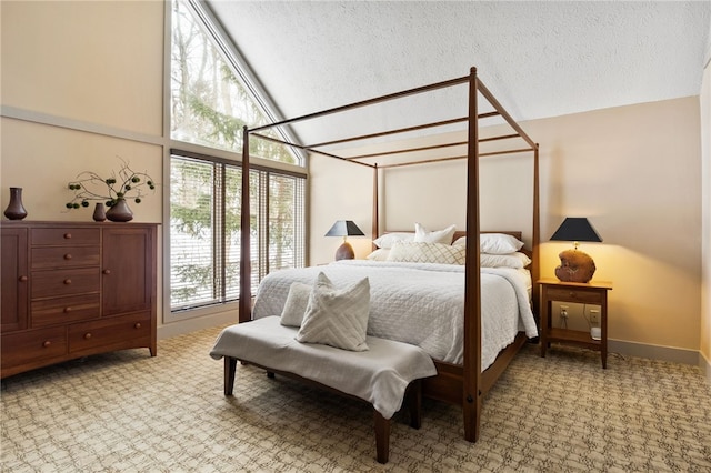 bedroom with high vaulted ceiling, carpet flooring, and a textured ceiling