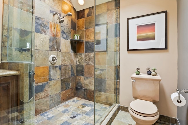 bathroom featuring toilet and a shower with shower door