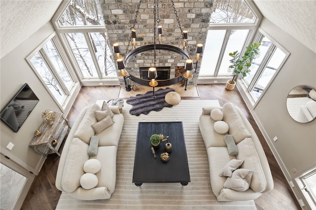 living room featuring hardwood / wood-style floors, a skylight, a textured ceiling, and a wood stove